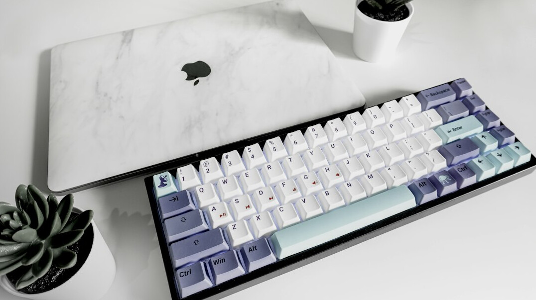Hands typing on a laptop at a desk